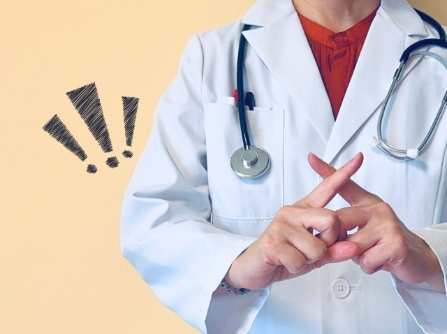 医師が手でバツ印をつくっている様子