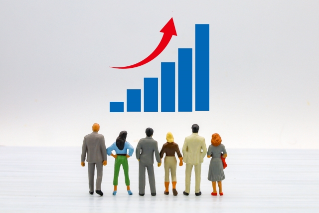 男女数名が上昇するグラフを見ている写真