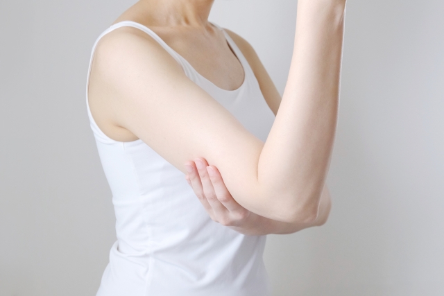 自分の腕を触る女性の写真