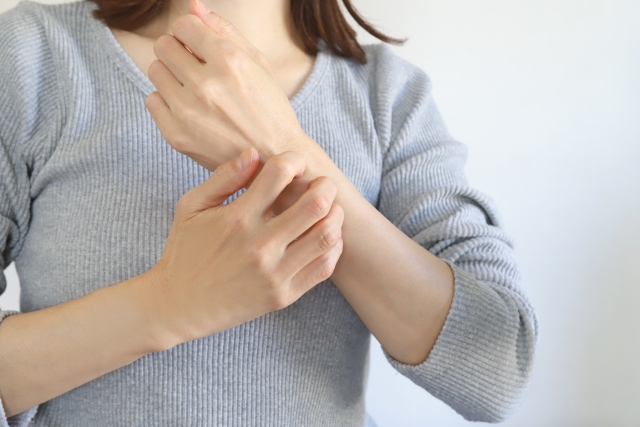 腕を掻いている女性の写真