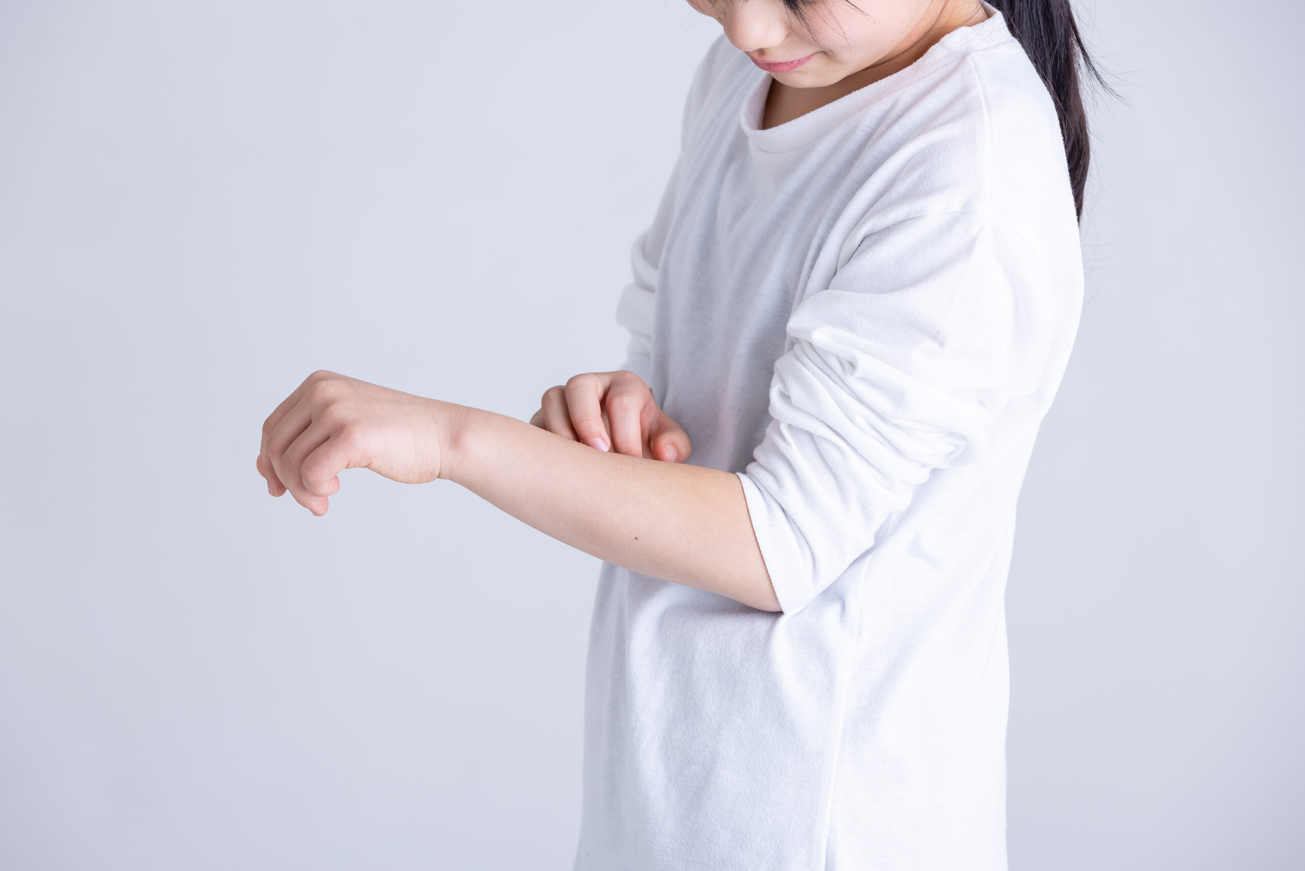 痒疹によるかゆみで腕をかいているイメージ