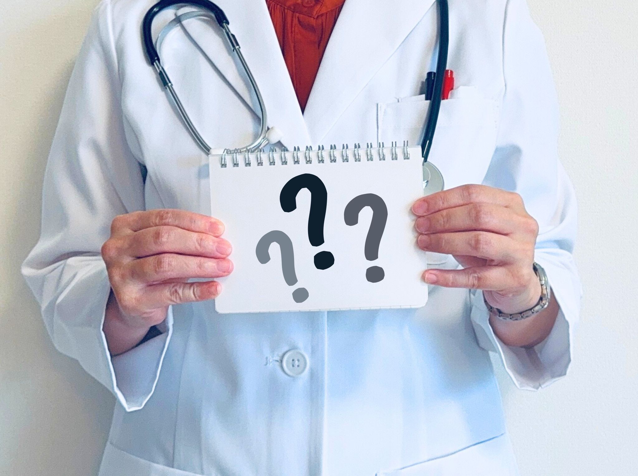 痒疹の原因を説明する医師が「？」マークの紙を持っている写真
