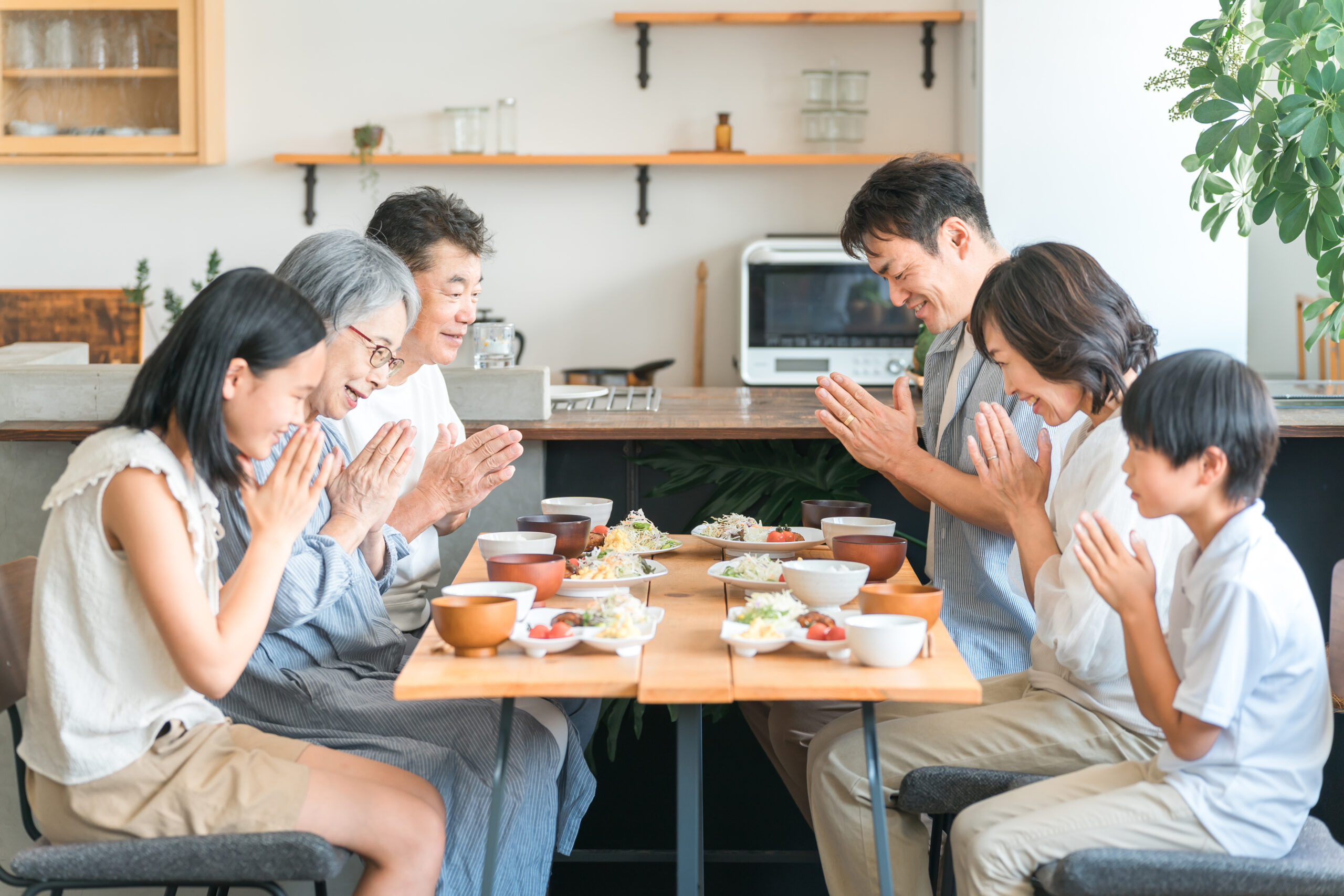食卓で野菜中心の食事を楽しむ家族の写真
