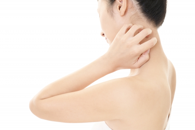 首元にかゆみを感じて痒く女性の写真