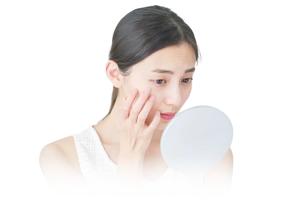 鏡を見てしわに悩んでいる女性
