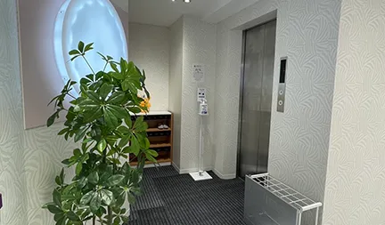 クリニックの入口と受付。スリッパへの履き替えや受付手続きのイメージ