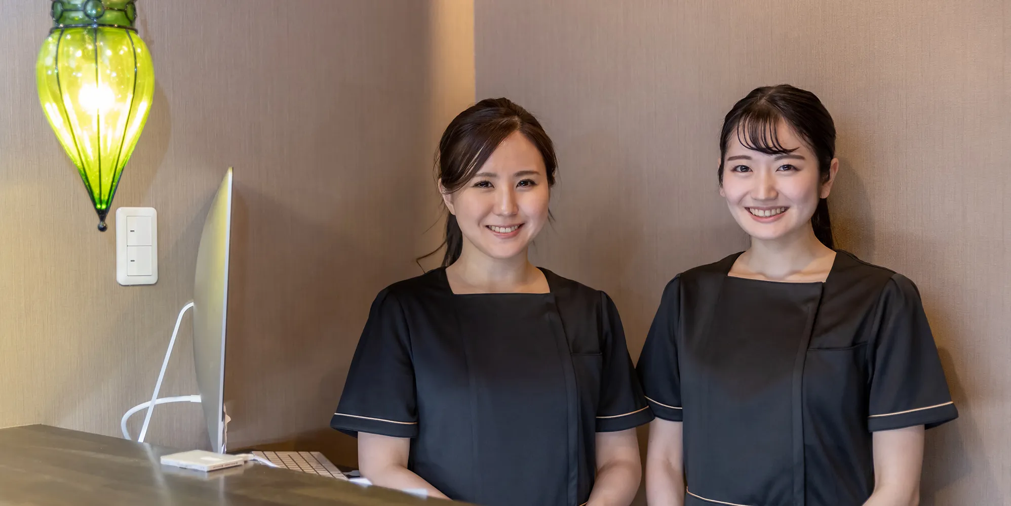 れいわクリニックの受付で笑顔で迎えるスタッフたち