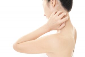 首元にかゆみを感じて痒く女性の写真