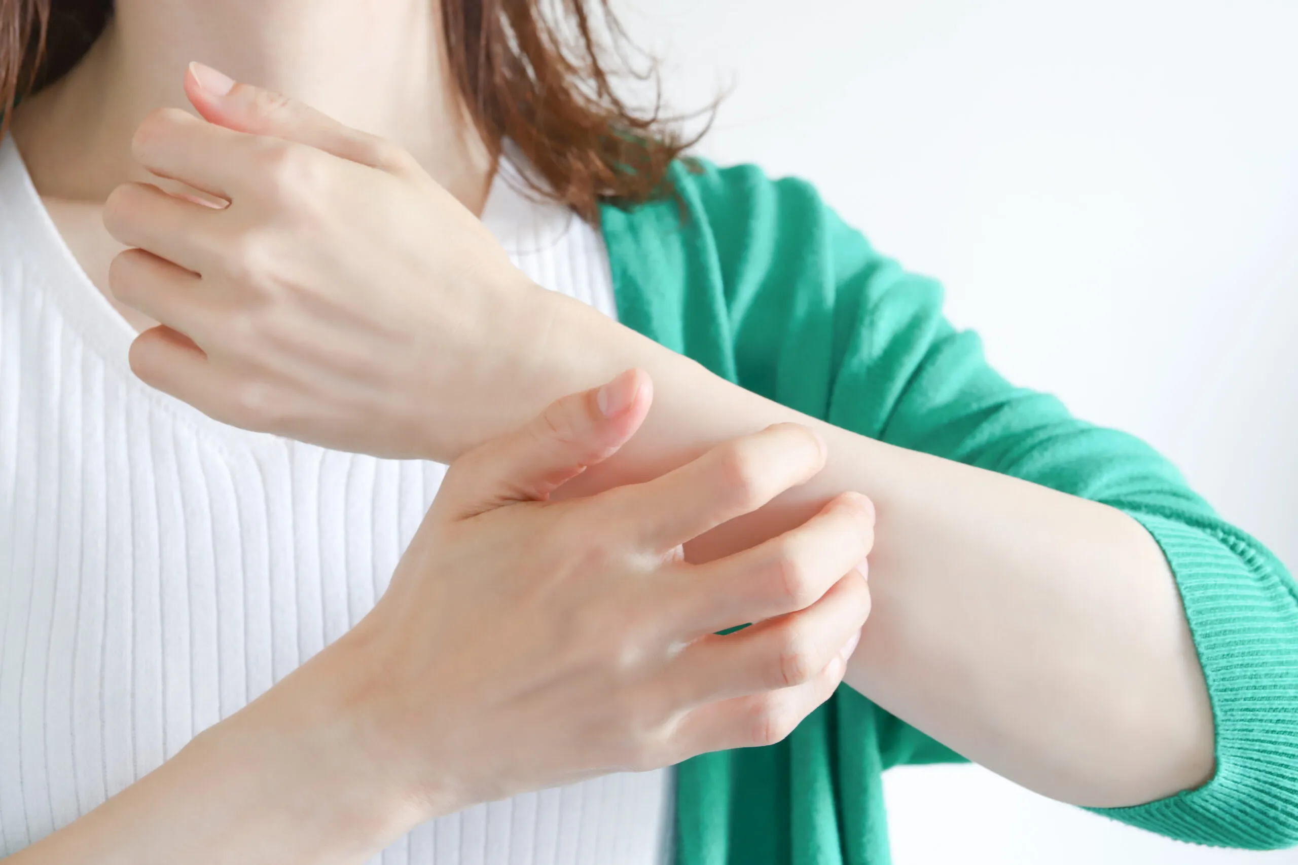 alt="蕁麻疹のかゆみで腕を掻いている女性のイメージ。新宿の皮膚科・クリニックでよく相談される症状
