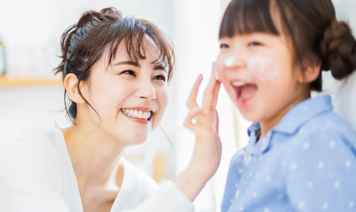 子どもに保湿クリームを塗る保護者、小児の皮膚疾患にも対応している